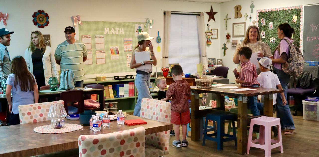 Parents and students visiting a decorated Pre-K3 classroom with a math bulletin board at Stephenville Christian Academy